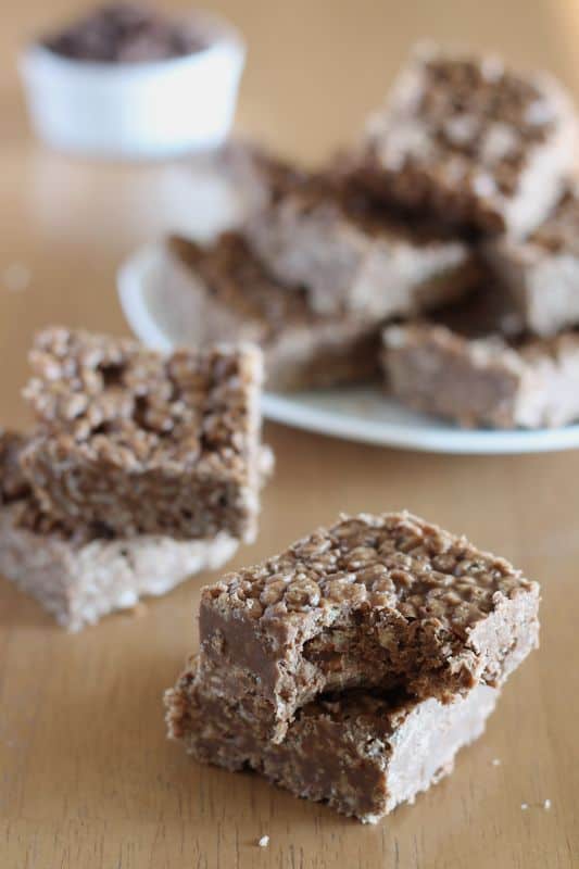 carob peanut butter rice krispy treats cut into squares in short stacks with wooden background