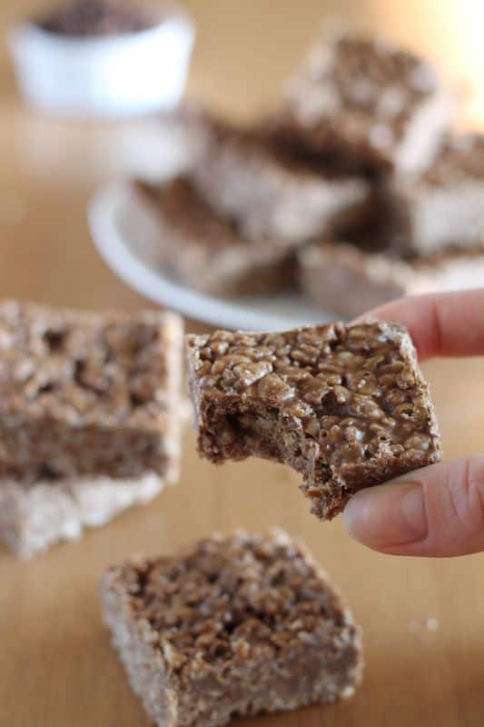 carob peanut butter rice krispy treats held in hand with bite taken out of it