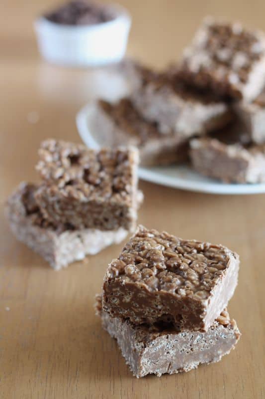 carob peanut rice krispy treats cut into squares in short stacks with wooden background