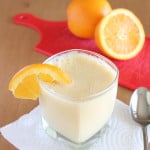 vegan orange Julius in small clear glass cup with sliced orange garnish