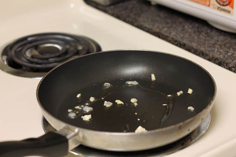 garlic and oil warming up in skillet on stovetop