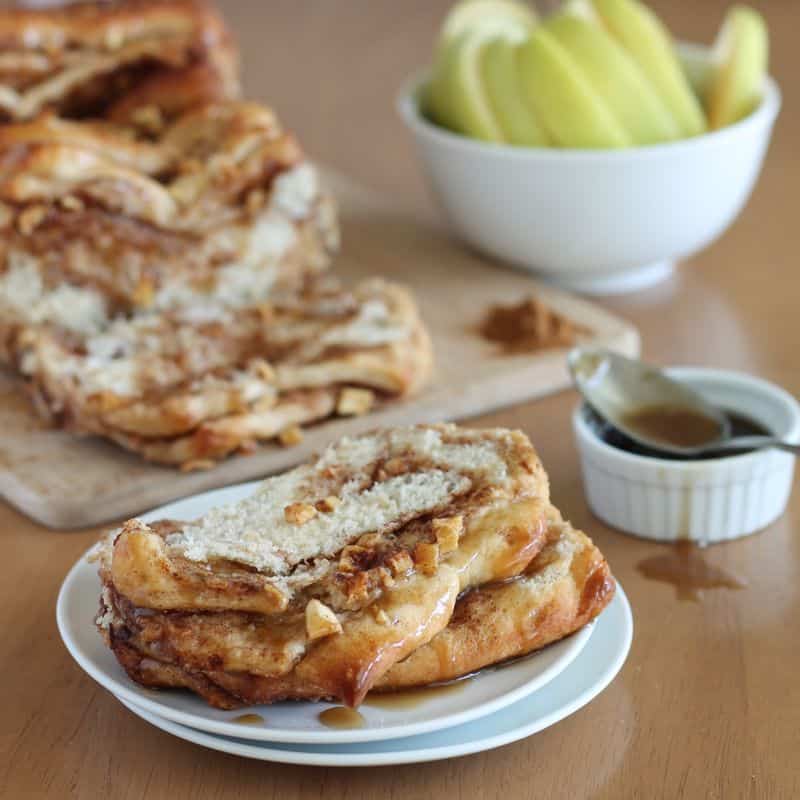 vegan caramel apple pull apart bread on white plate with wood background