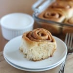 vegan cinnamon roll on white plate with wood background