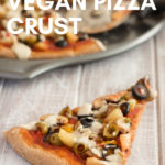 slice of vegan whole wheat pizza with white wooden background and text overlay