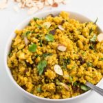 vegan curried quinoa in white bowl with white background
