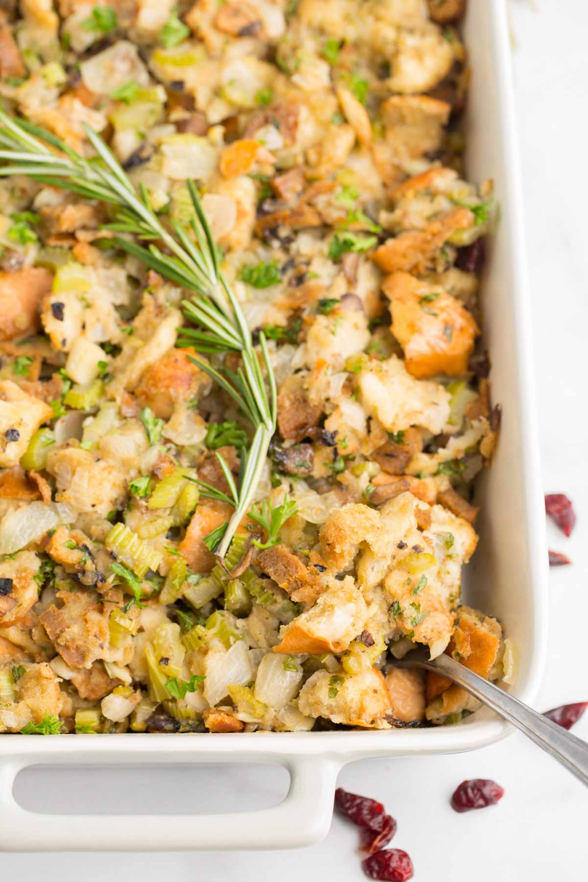 cooked vegan stuffing in white baking dish with white marble background